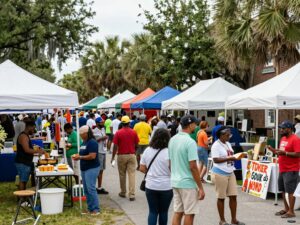 A lively scene from a Charleston festival with local cuisine and community members enjoying various activities.