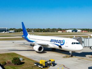 Breeze Airways airplane at Charleston International Airport with a clear sky.